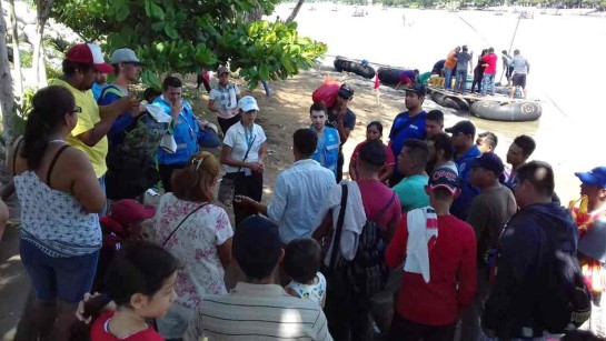 Personal från UNHCR hjälper människor på flykt från Honduras vid floden Suchiate,i södra Mexiko, som gränsar till Guatemala. 