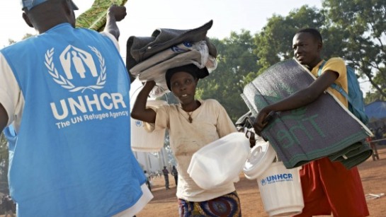 En kvinnor och hennes son får förnödenheter som plastmattor, dunkar, presenningar, hink och myggnät från UNHCR i Bossangoa. 