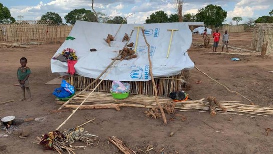 En liten pojke står utanför sitt tält i läger för internflyktingar i byn Nanjua i norra Moçambique.