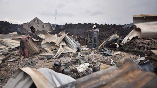 Invånare samlar ihop det som finns kvar i sina förstörda hem efter den glödande lavafloden från vulkanutbrottet på Nyiragongo.