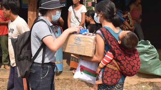 En mamma och hennes barn på flykt i Myanmar för nödpaket och skydd mot våldet.