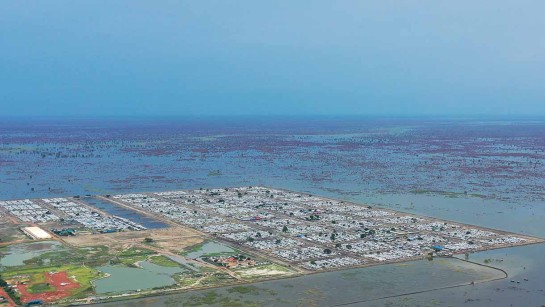 Tältlägret vid staden Bentiu, Sydsudan, ligger under vatten. Människor skyddas av diken och vallar. Efter fyra år av översvämingar är 900 000 människor i landet drabbade.