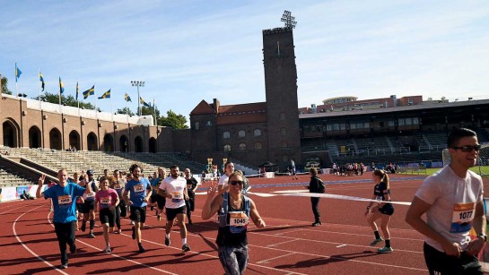Människor springer ett lopp på Olympiastadion i Stockholm
