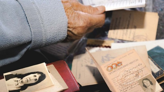 Baba Nina visar sina ID-handlingar under flykten.