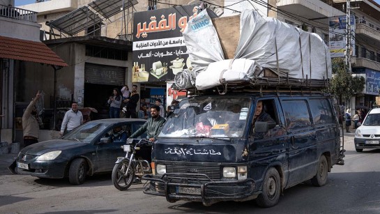 Bilar med packning på en gata i Syrien.