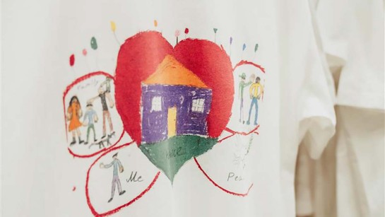 En teckning med  ett hjärta och hem ritad på en t-shirt.